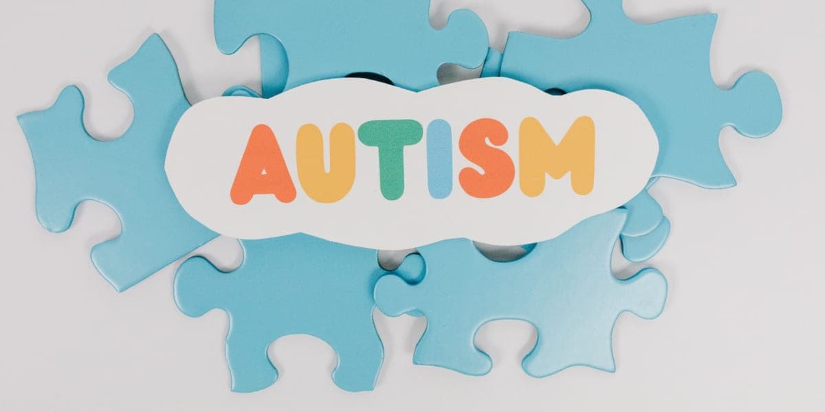 The word “autism” in colourful letters on blue puzzle pieces